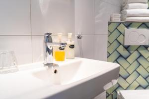 ein Badezimmer mit einem weißen Waschbecken mit Flaschen in der Unterkunft Ontbijthotel Kruller in Otterlo