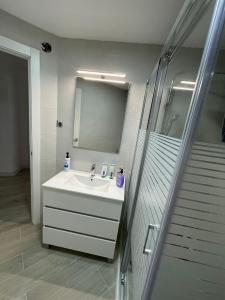 een witte badkamer met een wastafel en een douche bij Apartamento nuevo en Puertollano in Puertollano