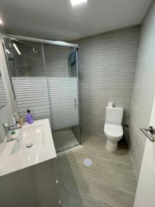 een badkamer met een douche, een toilet en een wastafel bij Apartamento nuevo en Puertollano in Puertollano