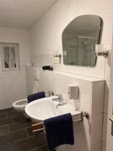 a bathroom with a sink and a toilet with a mirror at FeWo Nebenan in Bad Windsheim