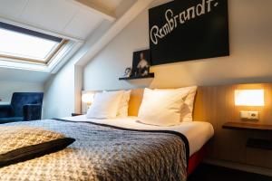 een hotelkamer met een bed en een bord aan de muur bij Ontbijthotel Kruller in Otterlo