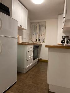 eine Küche mit weißen Schränken und einem weißen Kühlschrank in der Unterkunft FeWo Nebenan in Bad Windsheim