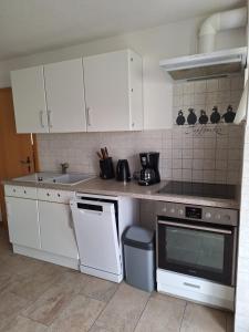 a kitchen with white cabinets and a stove top oven at Emma in Greifswald