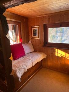 a small bed in a cabin with a window at Cozy 500 Years Old Walser Home in Alagna Valsesia