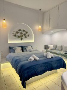 une chambre avec un grand lit avec des draps bleus dans l'établissement Central Cycladic Cove in Naxos Town, à Naxos Chora