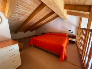 een slaapkamer met een rood bed op zolder bij Villa Dascia - Agenzia Cocal in Caorle