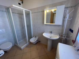 een badkamer met een douche, een wastafel en een toilet bij Villa Dascia - Agenzia Cocal in Caorle