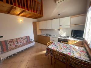 een keuken met een tafel en een bank in een kamer bij Villa Dascia - Agenzia Cocal in Caorle