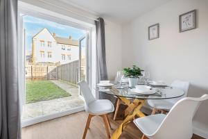 a dining room with a table and chairs and a large window at New modern & comfortable listing in Bedford