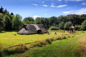 a hut in a field with people walking around it at Ontbijthotel Kruller in Otterlo