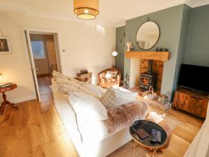 uma sala de estar com um sofá branco e uma lareira em Rose Cottage em Brough