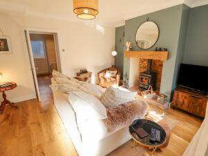 a living room with a white couch and a fireplace at Rose Cottage in Brough