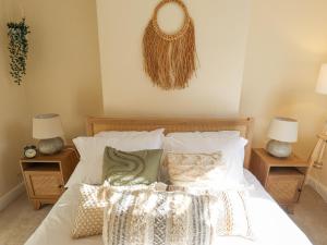 a bedroom with a bed with white sheets and pillows at Rose Cottage in Brough