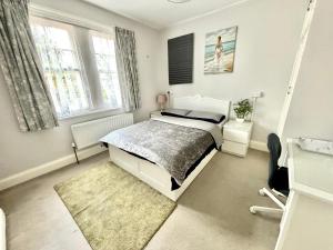 a white bedroom with a bed and a window at Winton house home stay in Bournemouth