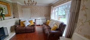 a living room with two leather couches and a window at Kilronan Holiday Homes in Kilronan