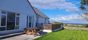 Kilronan Holiday Homes في Kilronan: منزل مع طاولة نزهة ومقعد