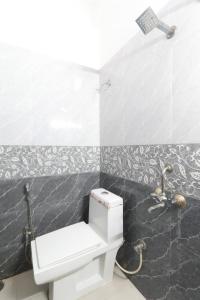 La salle de bains est pourvue de toilettes blanches et d'un lavabo. dans l'établissement Metro Regency Near Lucknow Junction- Couple Friendly Hotel, à Lucknow