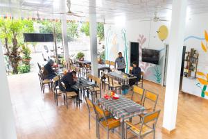 a group of people sitting at tables in a restaurant at Cat Ba Countryside Homestay in Cat Ba