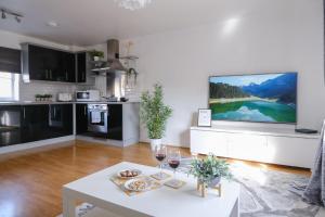 a living room with a white table and a tv at Sorrel House in Carterton