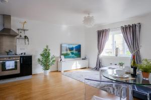 a living room with a table and a tv at Sorrel House Stylish 2 Bedroom 2 Bathroom in Carterton
