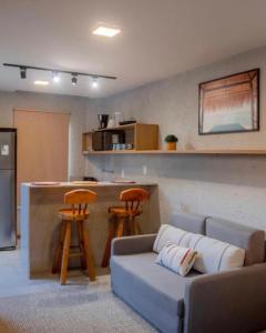 ein Wohnzimmer mit einem Sofa und einer Küche in der Unterkunft Vilarejo dos Milagres in São Miguel dos Milagres