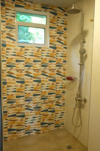 uma casa de banho com um chuveiro e uma parede em azulejo em VIEDA HOTEL em Caticlan