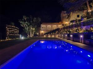 a swimming pool lit up at night with lights at Villa Tommaso Maruggi, Sicilia, con Jacuzzi e piscina privata in Alcamo