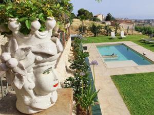 a large white statue of a woman next to a swimming pool at Villa Tommaso Maruggi, Sicilia, con Jacuzzi e piscina privata in Alcamo