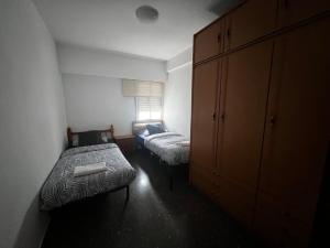 um pequeno quarto com 2 camas e um armário em HABITACIÓN CÉNTRICA EN ACOGEDORA CASA em Valência