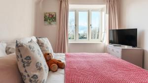 - un ours en peluche assis sur un lit dans une chambre dans l'établissement A handsome large 9 bedroom 17th Century village house moments from The Cotswold Way offering modern luxury in a peaceful location, à Frocester