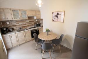una pequeña cocina con mesa de madera y sillas en Newly Renovated Central 2 Bedroom Apartment in Kozani, en Kozani