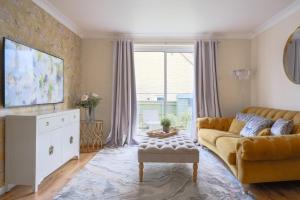 sala de estar con sofá amarillo y ventana en Bibury House a lovely 2 bed house sleeps 4, en Witney