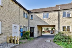 a brick house with a white door and a driveway at Bibury House a lovely 2 bed house sleeps 4 in Witney