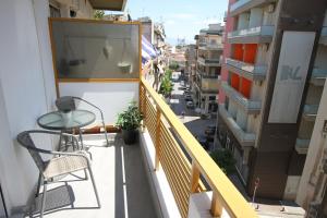 Un balcón con una mesa y sillas y una calle. en Newly Renovated Central 2 Bedroom Apartment in Kozani, en Kozani