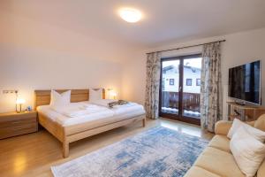 - une chambre avec un lit et une grande fenêtre dans l'établissement Ferienhaus am See, à Zell am See