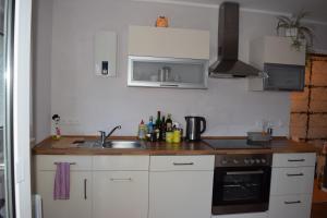 eine Küche mit weißen Schränken und einem Waschbecken in der Unterkunft Ferienwohnung Wörrstadt in Wörrstadt