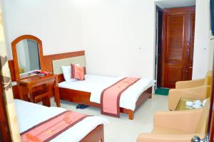 a hotel room with two beds and a mirror at Khách sạn Anh Đào in Lạng Sơn