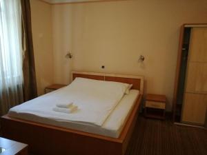 1 dormitorio con 1 cama con 2 toallas en Motel Royal, en Tuzla