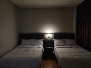 dwa łóżka w pokoju z lampką na ścianie w obiekcie Altori Park Hotel w mieście General Santos