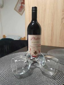 una botella de vino y copas en una mesa en Apartman Djokic 4 Studio en Požarevac