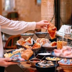 uma pessoa a segurar um pedaço de comida numa mesa em LOLA Boutique Hôtel - Bordeaux Centre em Bordeaux