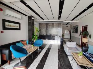 a living room with a couch and blue chairs at Altori Park Hotel in General Santos