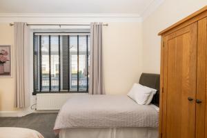 a bedroom with a bed and a window at Golfers Cottage close to beach, Monifieth and Carnoustie courses in Monifieth