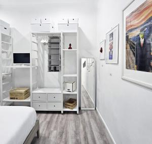 - une chambre blanche avec un lit et une télévision dans l'établissement Napulitano Assaje Home, à Naples