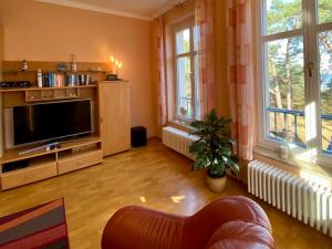 a living room with a flat screen tv and windows at Haus Sabine - Ferienwohnung Mine in Ahlbeck