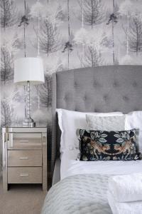 um quarto com uma cama e uma mesa de cabeceira com um candeeiro em Luxury one bed Apartment em Carterton