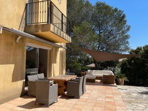 een patio met een tafel en stoelen en een balkon bij esterel-plage in Saint-Raphaël