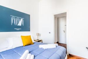 a bedroom with a blue bed with a yellow pillow at Bacoli Sveva Luxury House - Terrace & Design in Bacoli