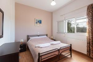 a bedroom with a bed and a window at Domas Blue Studio Villa With Private Pool and Panoramic View in Loutra +21 photos