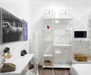 - une chambre blanche avec un bureau blanc et une télévision dans l'établissement Napulitano Assaje Home, à Naples